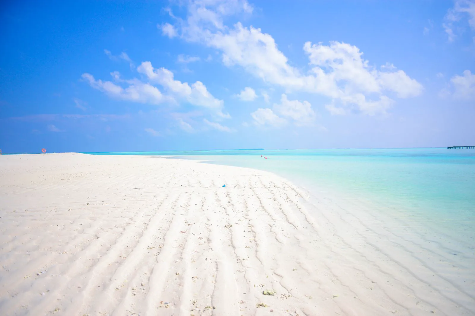 Weißer Sandstrand mit Palmen und türkisfarbenem Meer auf den Malediven