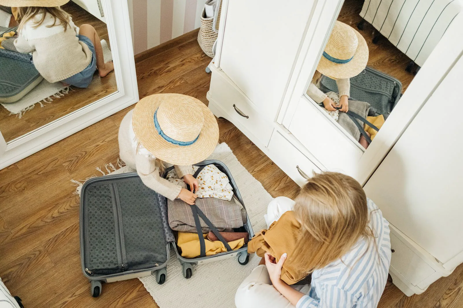 Mutter und Kind packen gemeinsam einen Reisekoffer