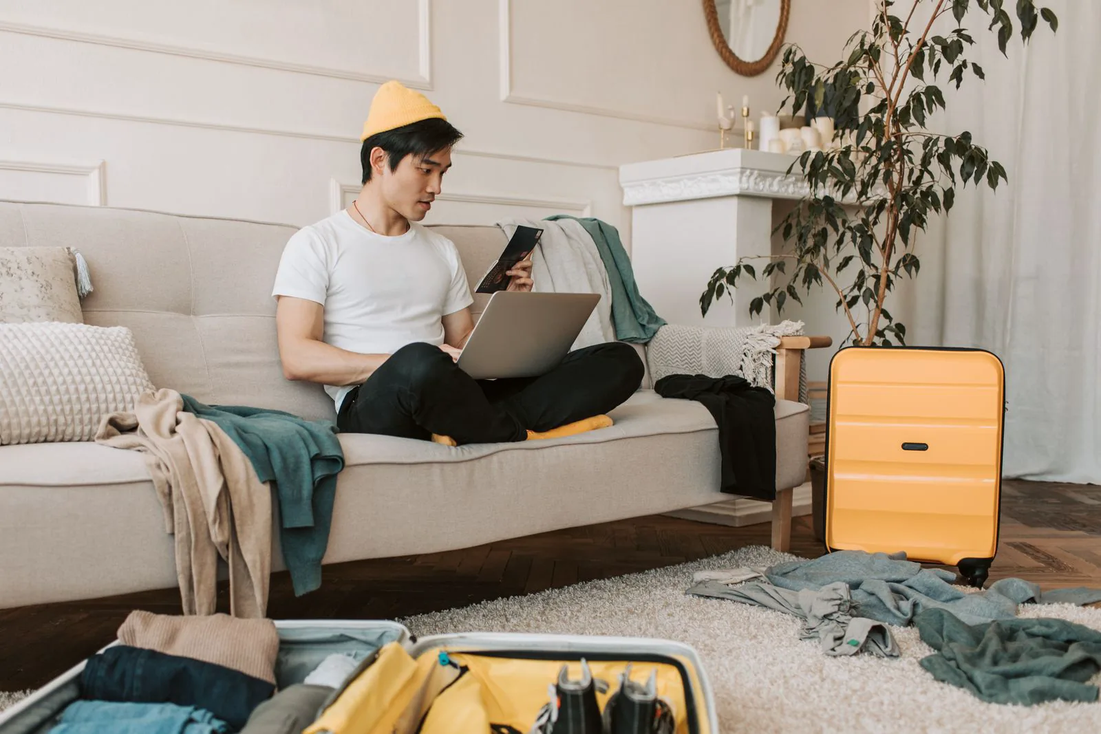 Reisender mit Laptop und Koffer im Wohnbereich