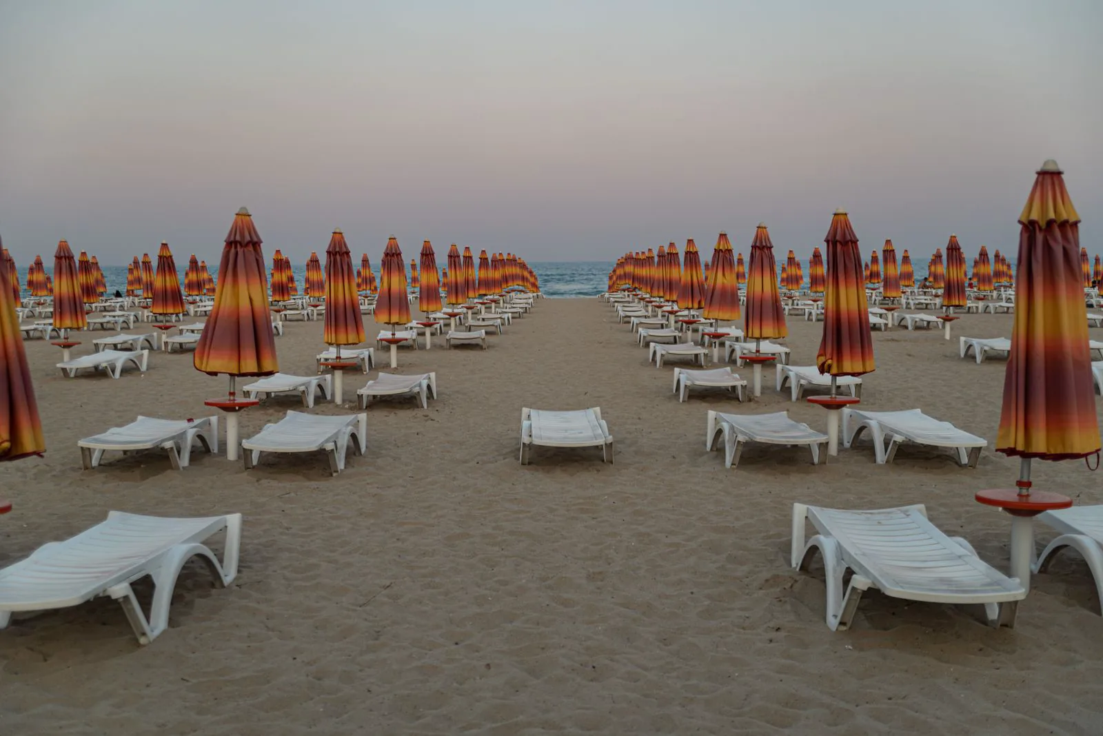 Leere Strandliegen und Schirme am Abend